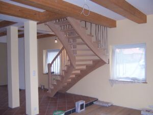 Das Foto zeigt eine Frei-Treppe mit einem 90 Grad Bogen in den ersten Stock.