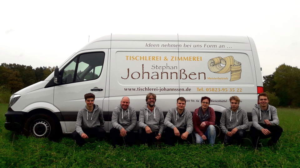 Foto zeigt die Mitarbeiter der Tischlerei Stephan Johannßen vor einem Lieferwagen.